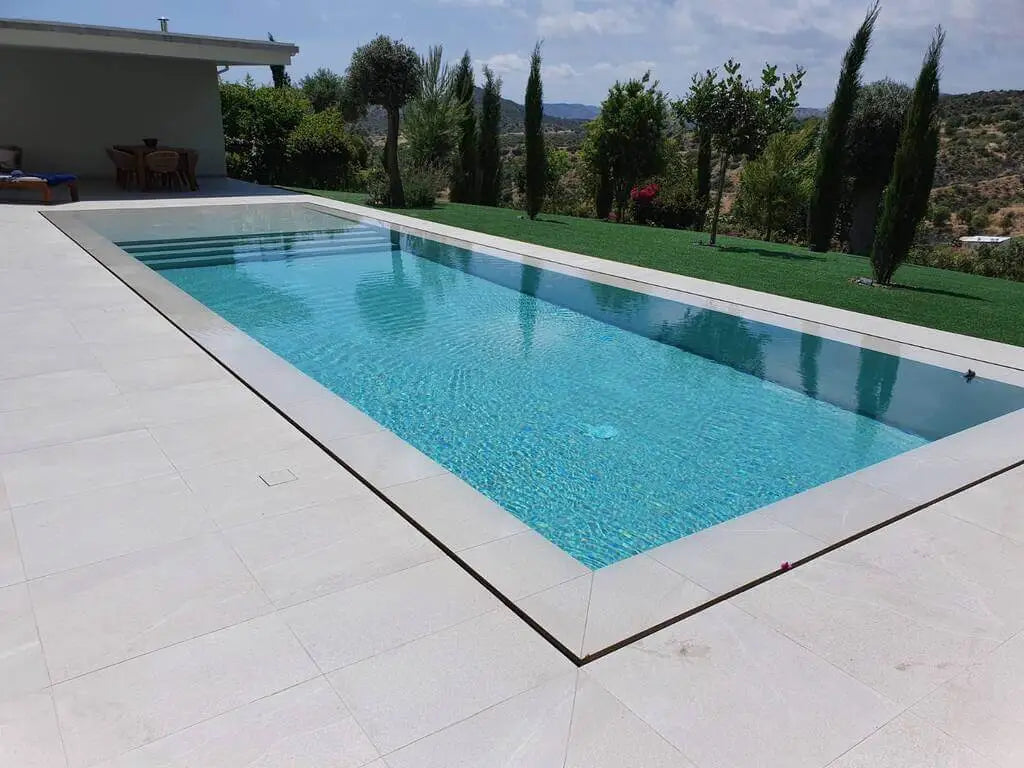 Pool mit Überlaufrinne in grüner Landschaft